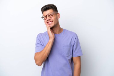 Beyaz arka planda diş ağrısı çeken beyaz tenli genç bir adam.