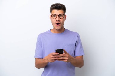 Beyaz arka planda izole genç beyaz adam şaşırdı ve bir mesaj gönderiyor