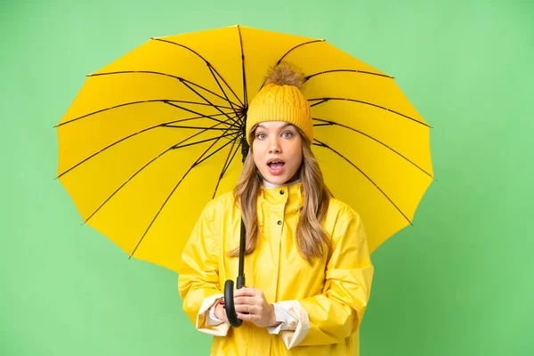 穿着防雨外套 披着雨伞的小女孩 有着令人惊讶的面部表情 — 图库照片