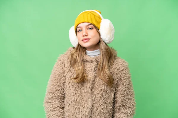 年轻姑娘披着冬衣 在孤零零的色彩斑斓的背景上嬉笑 — 图库照片