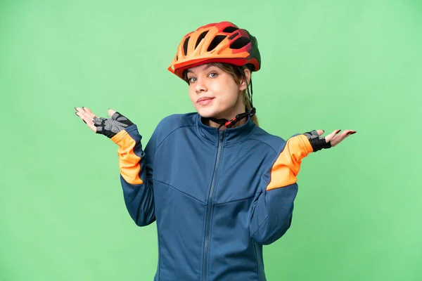 Fiatal Kerékpáros Lány Elszigetelt Chroma Kulcsfontosságú Háttér Kétségek Miközben Felemeli — Stock Fotó