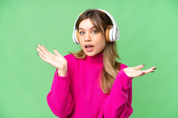 Chica Joven Sobre Aislado Croma Clave Fondo Sorprendido Escuchar Música — Foto de Stock