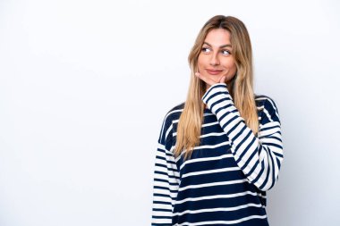 Young Uruguayan woman isolated on white background thinking an idea while looking up