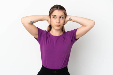 Beyaz arka planda izole edilmiş genç beyaz kadın hayal kırıklığına uğramış ve kulaklarını kapatmış.