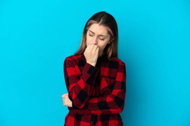 Kafkasyalı genç bir kadın mavi arka planda izole edilmiş. Şüpheleri var.