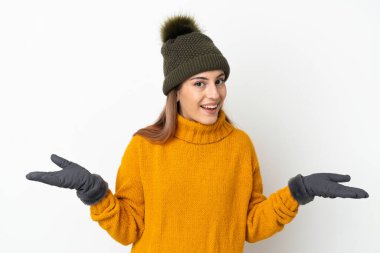 Young girl with winter hat isolated on white background with shocked facial expression