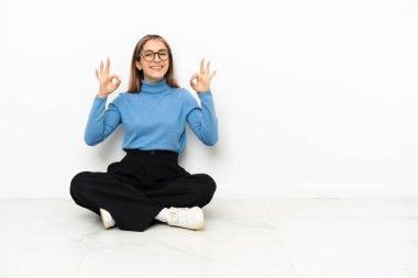 Young Caucasian woman sitting on the floor in zen pose
