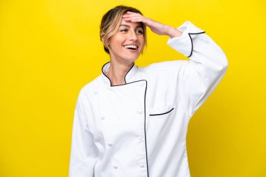 Uruguayan chef woman isolated on yellow background has realized something and intending the solution
