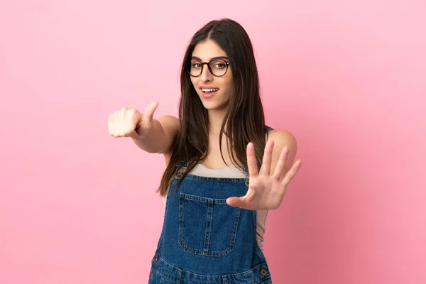 Young caucasian woman isolated on pink background counting six with fingers