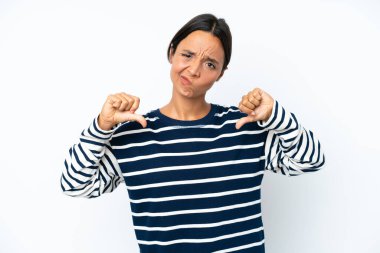 Young hispanic woman isolated on white background showing thumb down with two hands