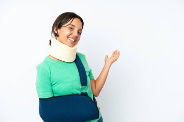 Young hispanic woman wearing a neck brace and sling isolated on white background extending hands to the side for inviting to come