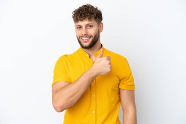 Beyaz arka planda izole edilmiş yakışıklı beyaz bir adam baş parmak hareketi yapıyor.