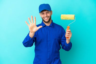 Kafkasyalı ressam mavi arka planda izole edilmiş, parmaklarıyla beşi sayıyor.