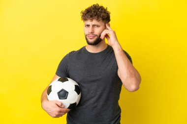 Yakışıklı genç futbolcu sarı arka planda izole edilmiş şüpheleri var.