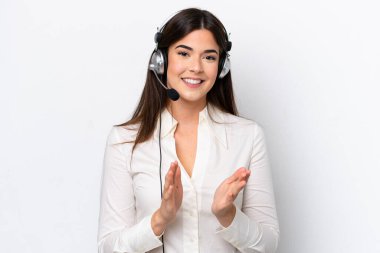 Beyaz arka planda izole edilmiş kulaklıkla çalışan beyaz pazarlamacı kadın bir konferansta sunumdan sonra alkışlıyor.