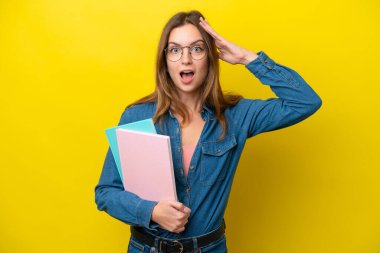 Sarı arka planda, sürpriz bir ifadeyle izole edilmiş genç beyaz bir kadın.