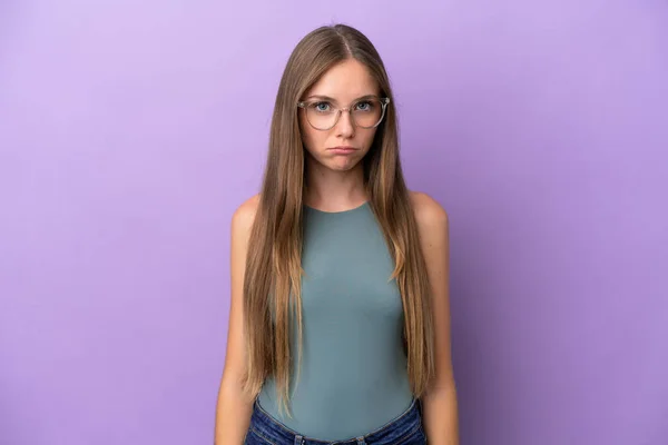Young Lithuanian woman isolated on purple background with sad expression