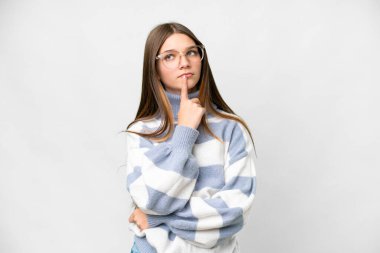 Teenager girl over isolated white background having doubts while looking up