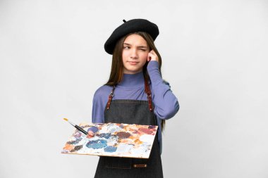 Young artist man holding a palette over isolated white background frustrated and covering ears