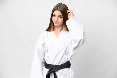 Teenager girl doing karate over isolated white background having doubts