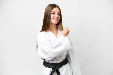 Teenager girl doing karate over isolated white background celebrating a victory