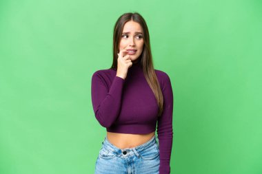 Young beautiful woman over isolated chroma key background nervous and scared