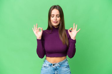 Young beautiful woman over isolated chroma key background in zen pose
