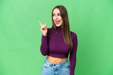 Young beautiful woman over isolated chroma key background intending to realizes the solution while lifting a finger up