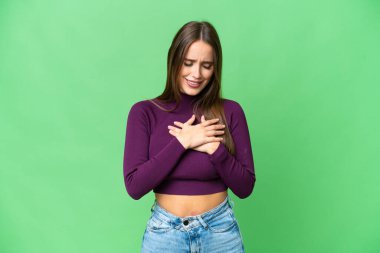 Young beautiful woman over isolated chroma key background having a pain in the heart