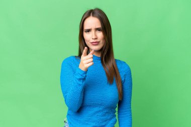 Young beautiful woman over isolated chroma key background frustrated and pointing to the front