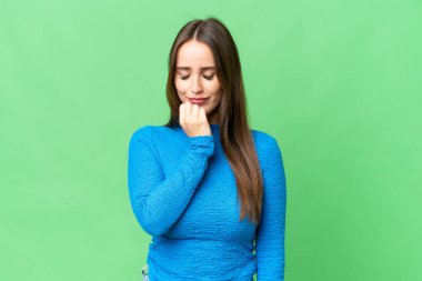 Young beautiful woman over isolated chroma key background having doubts