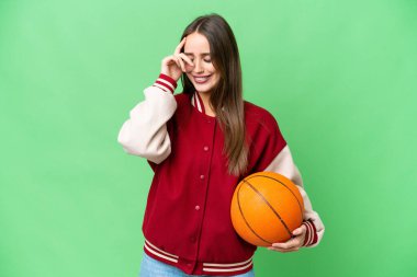 Young beautiful woman playing basketball over isolated chroma key background laughing