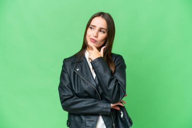 Young beautiful woman over isolated chroma key background having doubts