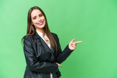 Young beautiful woman over isolated chroma key background pointing finger to the side