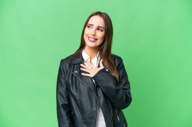 Young beautiful woman over isolated chroma key background looking up while smiling