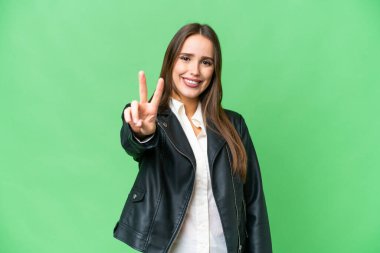 Young beautiful woman over isolated chroma key background smiling and showing victory sign