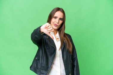 Young beautiful woman over isolated chroma key background showing thumb down with negative expression