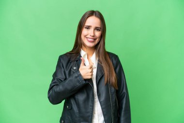 Young beautiful woman over isolated chroma key background giving a thumbs up gesture