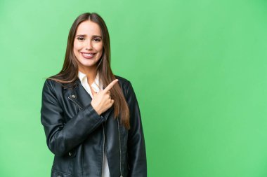 Young beautiful woman over isolated chroma key background pointing to the side to present a product