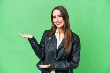 Young beautiful woman over isolated chroma key background extending hands to the side for inviting to come