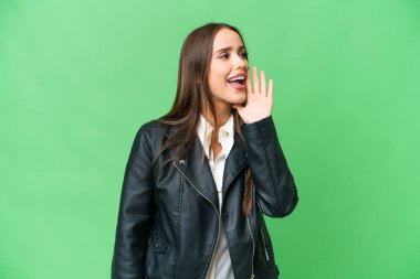 Young beautiful woman over isolated chroma key background shouting with mouth wide open to the side