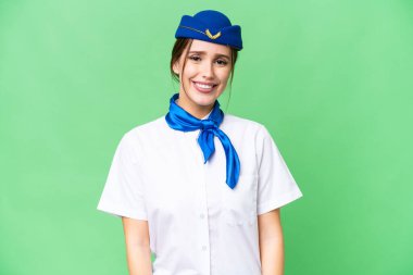 Airplane stewardess over isolated chroma key background laughing
