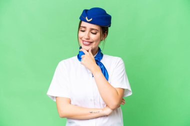 Airplane stewardess over isolated chroma key background looking to the side