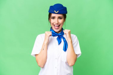 Airplane stewardess over isolated chroma key background celebrating a victory in winner position