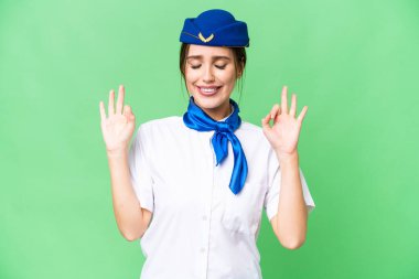 Airplane stewardess over isolated chroma key background in zen pose