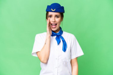 Airplane stewardess over isolated chroma key background with surprise and shocked facial expression