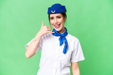 Uçak hostesi izole edilmiş krom anahtar arka planda telefon jesti yapıyor. Bana geri dönüş işareti ver.