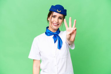 Uçak hostesi izole edilmiş krom anahtar arka planda mutlu ve parmaklarıyla üçe kadar sayıyor