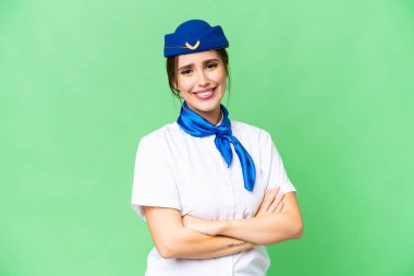 Airplane stewardess over isolated chroma key background with arms crossed and looking forward