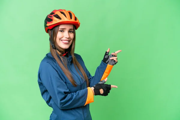 Young Cyclist Woman Isolated Chroma Key Background Pointing Finger Side — Stockfoto